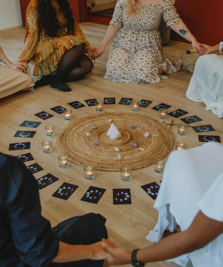 Women sitting in ritual circle with candles and cards