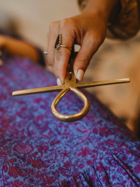 Hand holding an ankh symbol